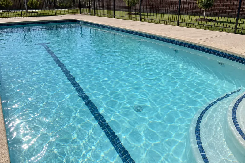 Full community pool with a white quartz finish and a dark lane line