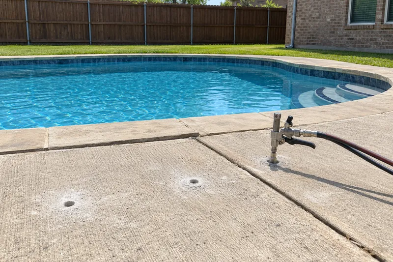 Foam injected under a sunken pool deck slab through drilled ports