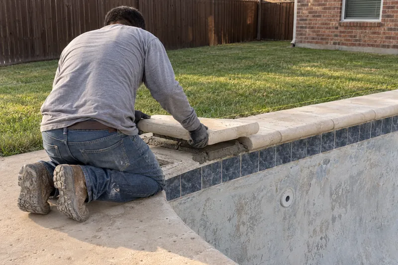 Limestone coping stone set on a mortar bed along a pool edge