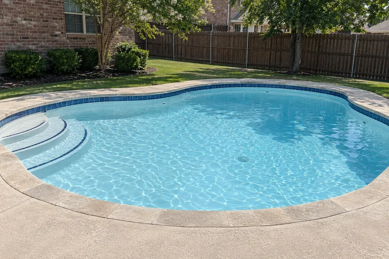 Backyard pool with new white plaster and bright light blue water