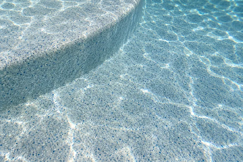 Speckled light blue quartz pool finish under clear water